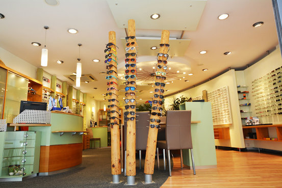 Modernes Optiker-Geschäft mit großer Auswahl an Brillen und Sonnenbrillen im Verkaufsraum.